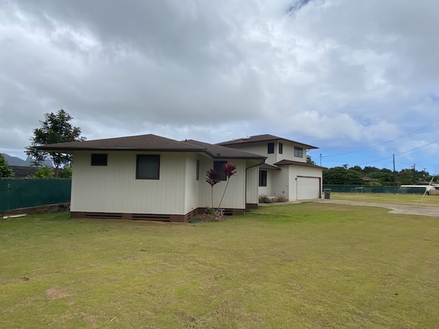 exterior space featuring a garage and a lawn