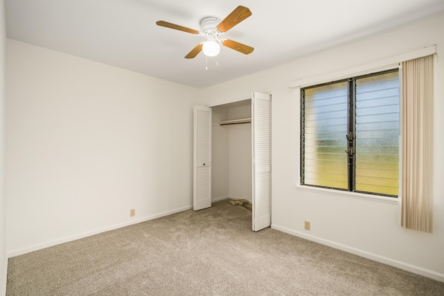 unfurnished bedroom featuring light colored carpet, a closet, and ceiling fan