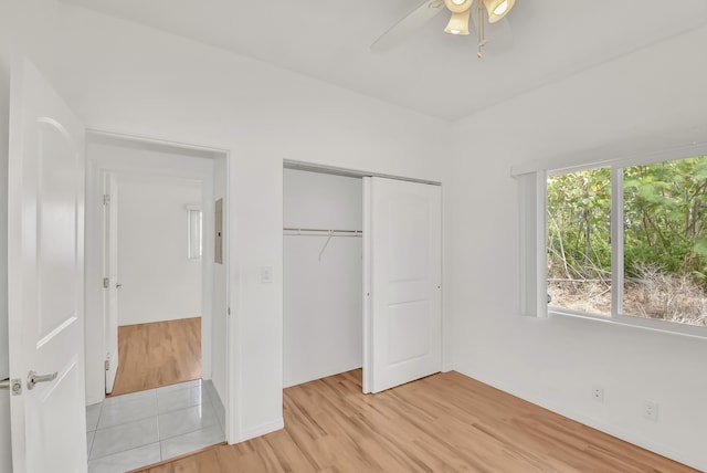 unfurnished bedroom with ceiling fan, light hardwood / wood-style floors, and a closet