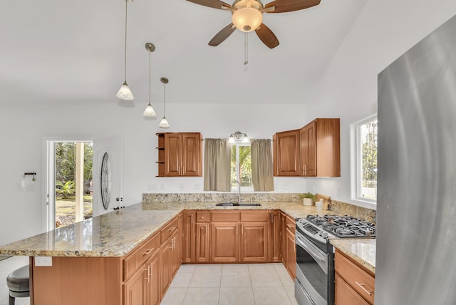 kitchen with sink, appliances with stainless steel finishes, hanging light fixtures, vaulted ceiling, and kitchen peninsula