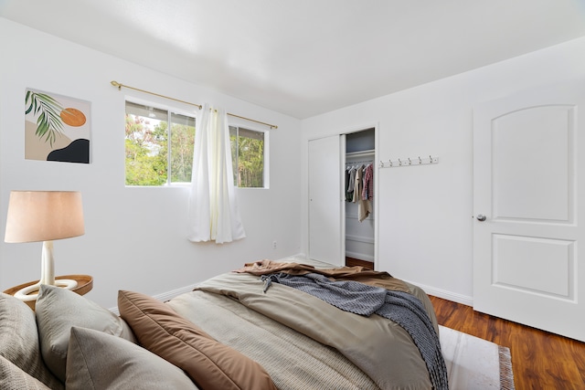 bedroom with dark wood-type flooring and a closet