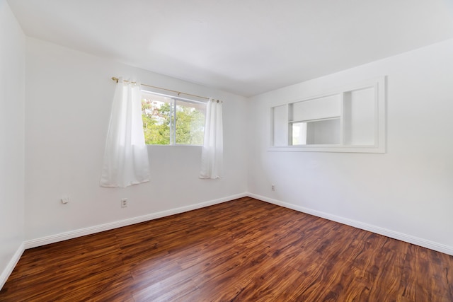 empty room with dark hardwood / wood-style flooring