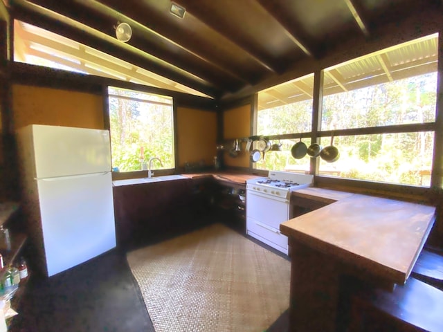 kitchen featuring lofted ceiling, sink, and white appliances