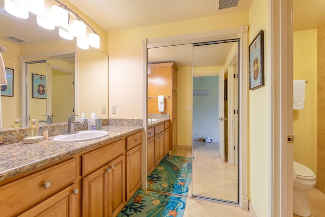 bathroom with vanity, tile patterned floors, and toilet