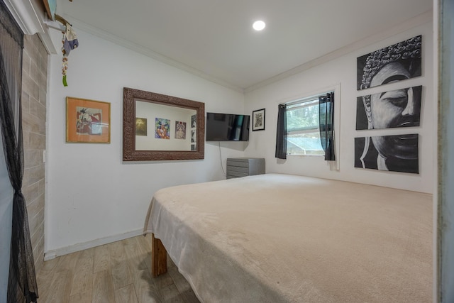 bedroom with crown molding and light hardwood / wood-style floors