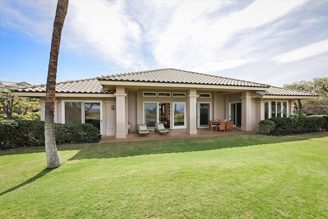 rear view of house featuring a lawn and a patio