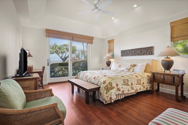 bedroom featuring a raised ceiling, dark hardwood / wood-style floors, access to outside, and ceiling fan