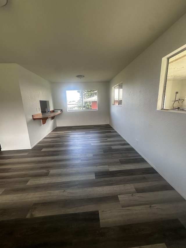 unfurnished room with dark wood-type flooring