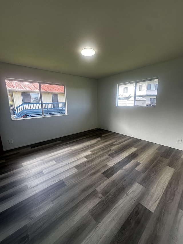 unfurnished room with dark hardwood / wood-style flooring