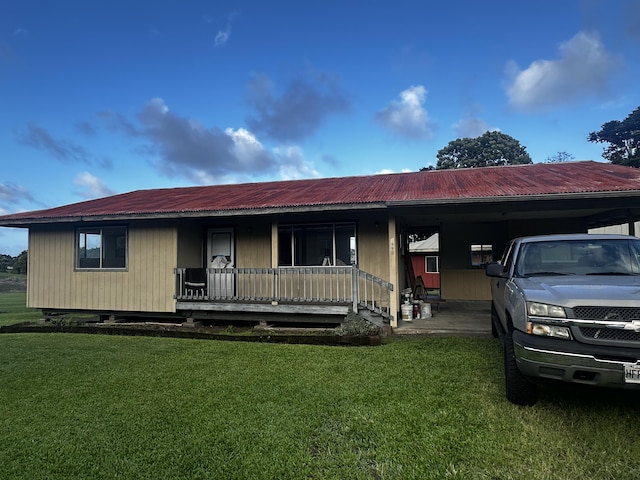 view of front of home with a carport, covered porch, and a front lawn