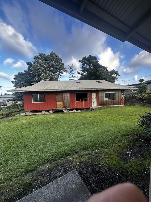 rear view of property featuring a lawn