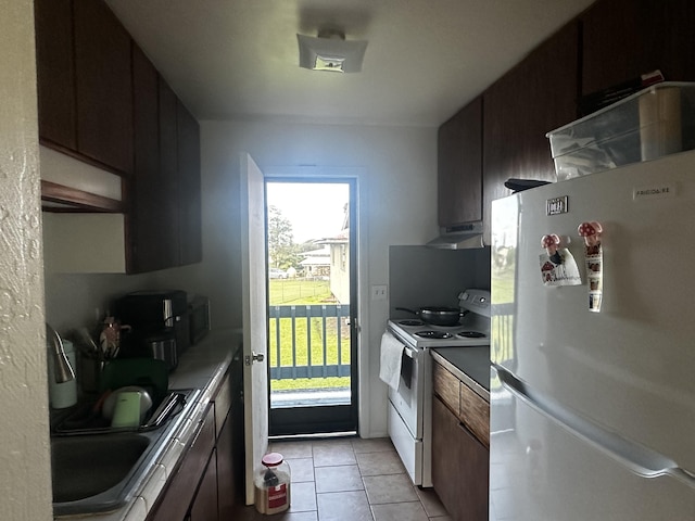 kitchen featuring light tile patterned flooring, white appliances, sink, and dark brown cabinets