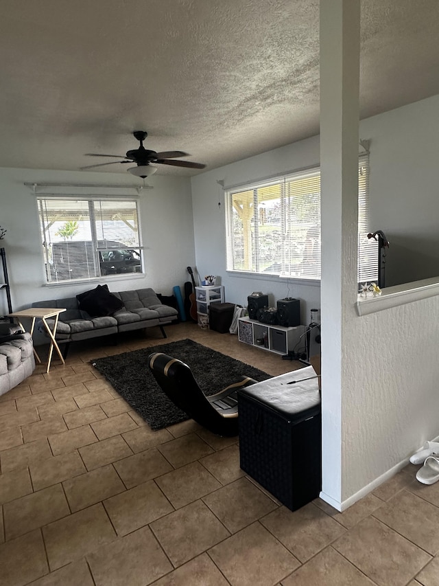 living room with light tile patterned floors, a textured ceiling, and ceiling fan