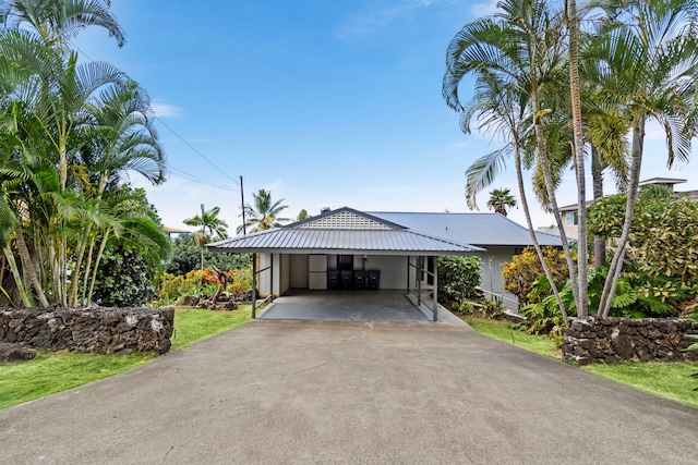 view of front facade featuring metal roof, a carport, and driveway