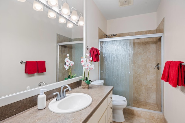 bathroom featuring vanity, toilet, and a shower with door