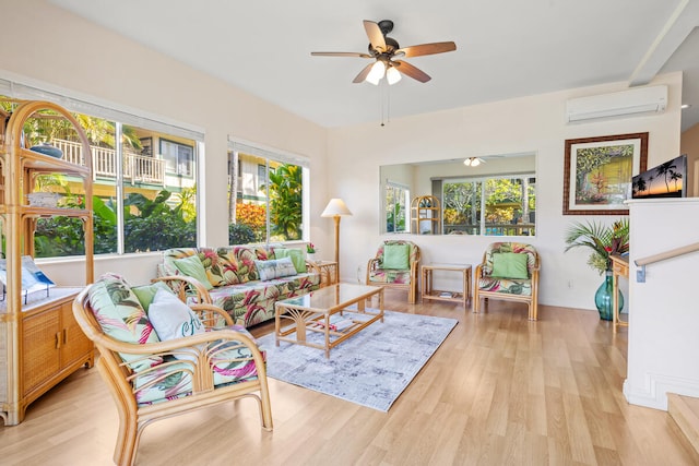 living room featuring ceiling fan, a wall mounted AC, and light hardwood / wood-style floors