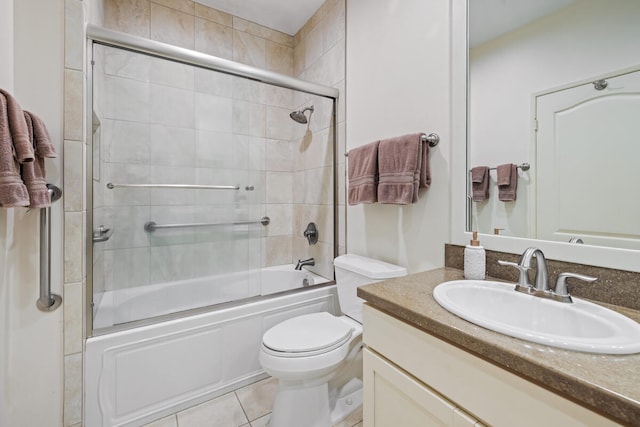 full bathroom featuring tile patterned floors, vanity, toilet, and combined bath / shower with glass door