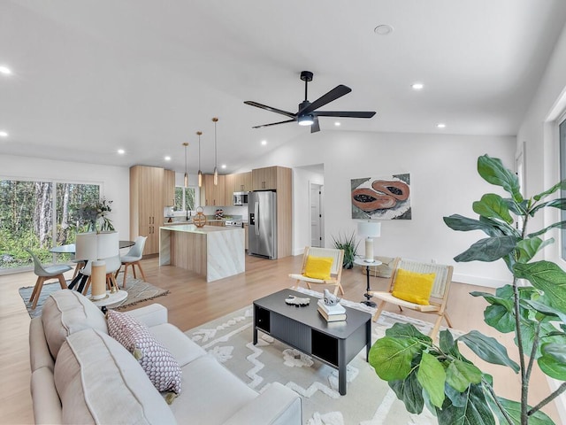 living room with vaulted ceiling, ceiling fan, and light hardwood / wood-style floors