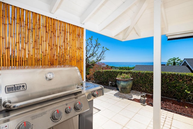 view of patio with area for grilling and a water view