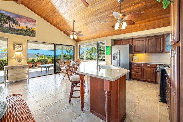 kitchen with sink, a breakfast bar area, appliances with stainless steel finishes, plenty of natural light, and a kitchen island with sink