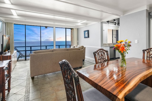 dining space featuring beam ceiling and light tile patterned floors