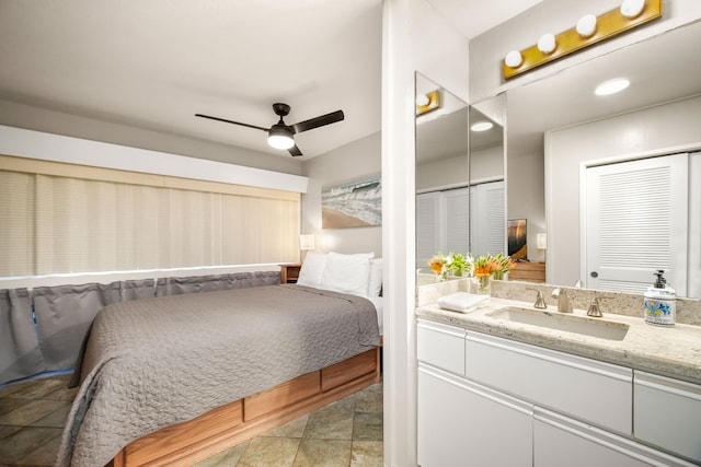 bedroom featuring multiple closets, sink, and ceiling fan