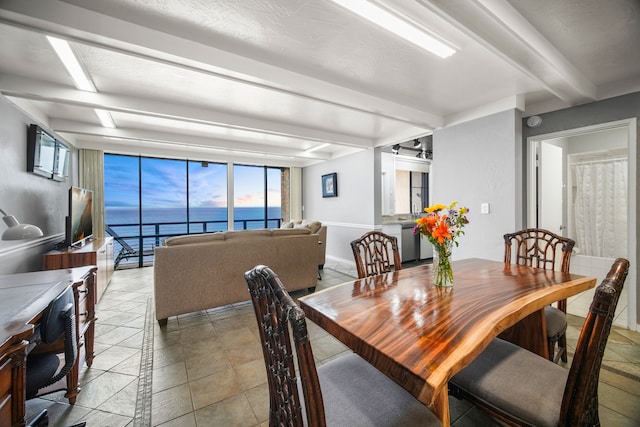 dining area featuring beamed ceiling