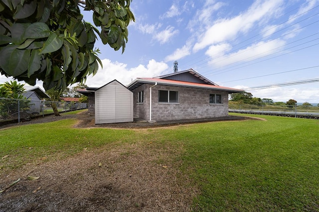 view of side of property with a shed and a lawn