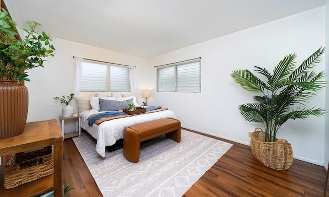 bedroom with dark hardwood / wood-style flooring and multiple windows