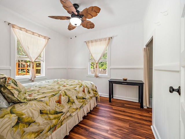 bedroom with dark hardwood / wood-style flooring, ornamental molding, and ceiling fan