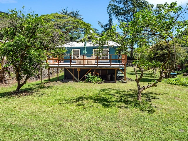 rear view of house with a deck and a lawn