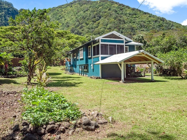 back of house featuring a mountain view and a yard