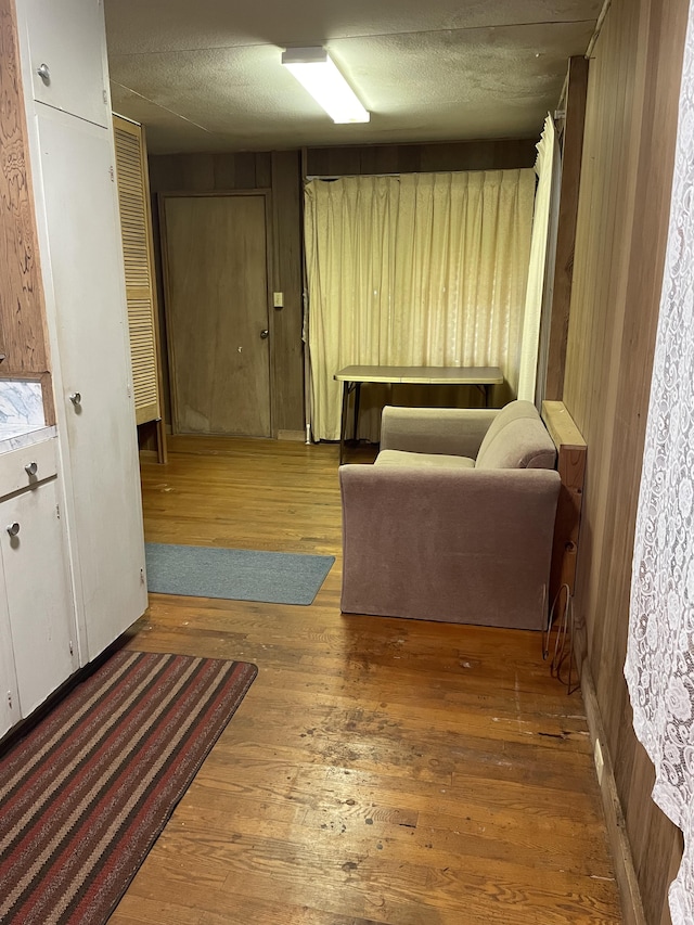 hall with wood-type flooring and wood walls