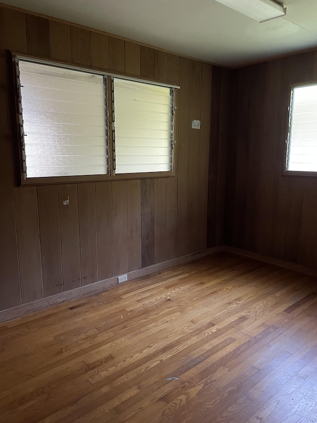 spare room with wooden walls and light hardwood / wood-style floors