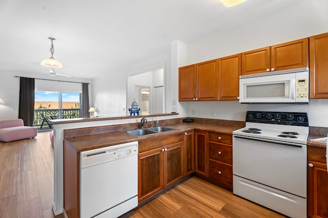 kitchen with decorative light fixtures, sink, light hardwood / wood-style floors, kitchen peninsula, and white appliances