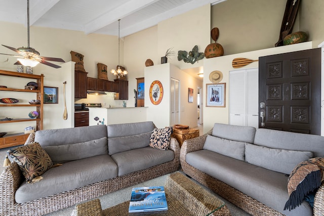 living room featuring beam ceiling, ceiling fan with notable chandelier, and a towering ceiling