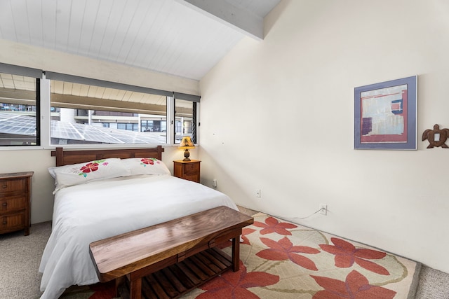 bedroom featuring light carpet and vaulted ceiling with beams