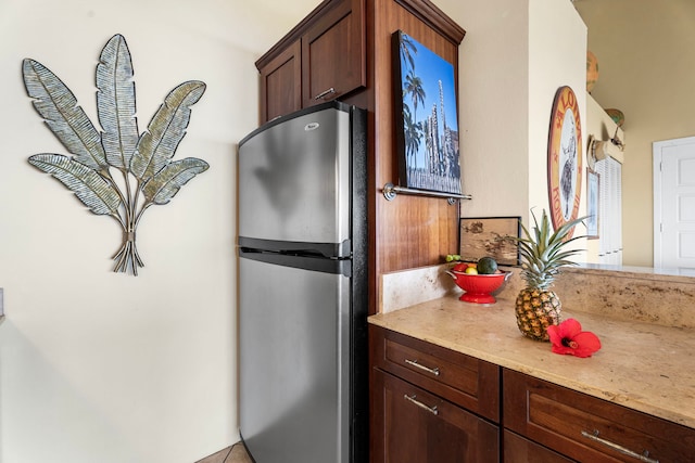 kitchen with stainless steel refrigerator and dark brown cabinets