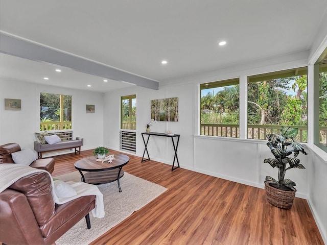 living area featuring beam ceiling, baseboards, wood finished floors, and recessed lighting