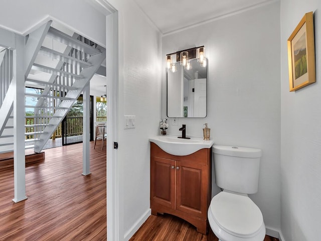 bathroom featuring vanity, wood finished floors, toilet, and baseboards