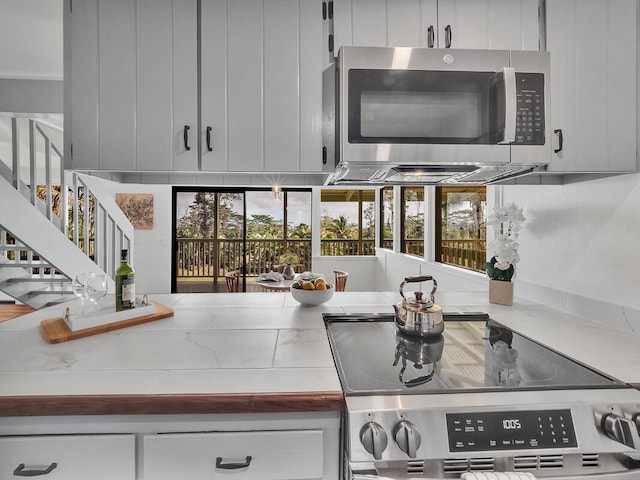 kitchen with stainless steel appliances, light countertops, and white cabinets