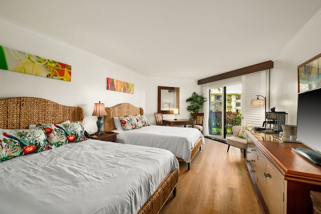 bedroom with crown molding and light hardwood / wood-style floors