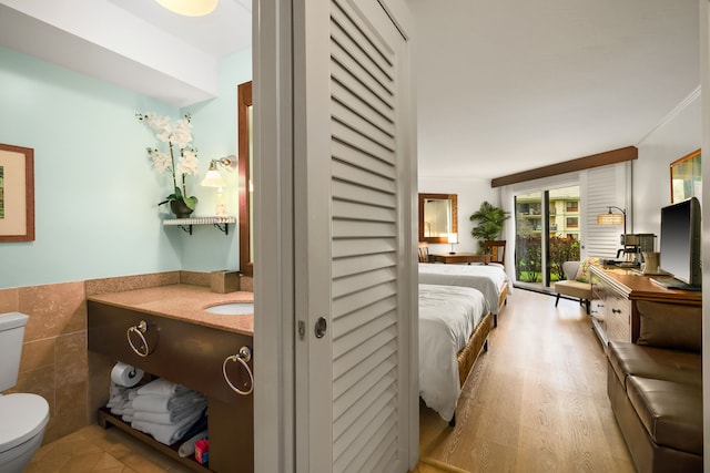 bedroom with tile walls and wood-type flooring