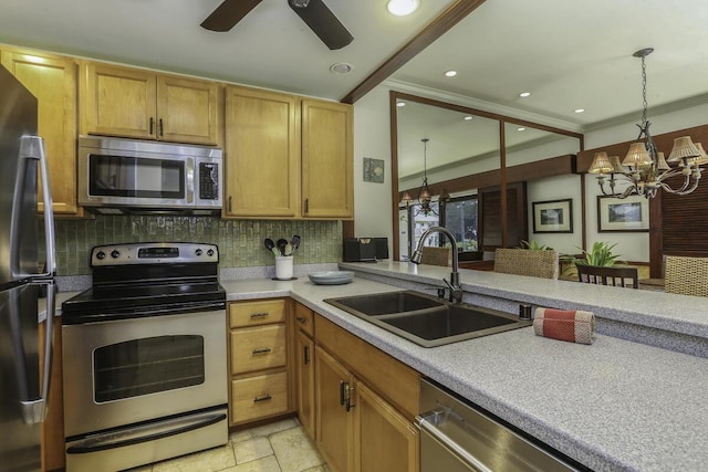 kitchen featuring appliances with stainless steel finishes, pendant lighting, sink, decorative backsplash, and ornamental molding