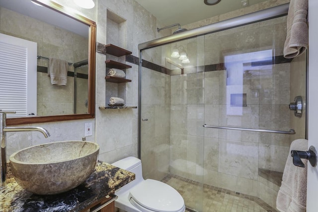 bathroom featuring vanity, toilet, and a shower with door