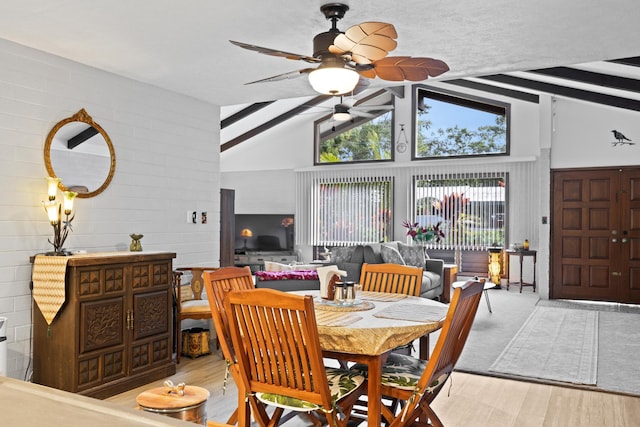 dining space with beamed ceiling, ceiling fan, high vaulted ceiling, and light hardwood / wood-style floors