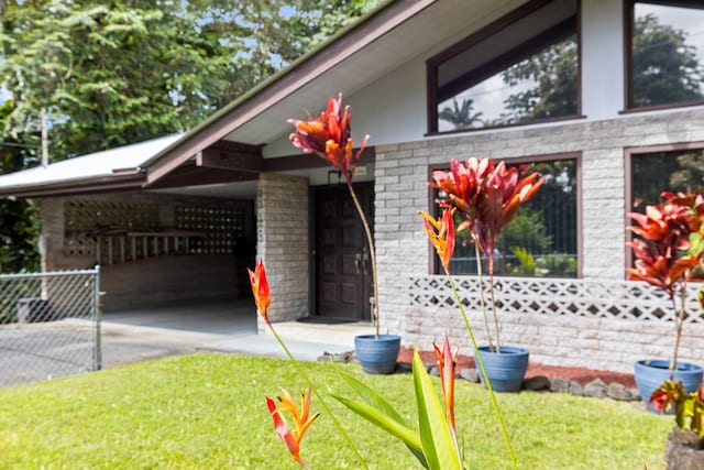 view of side of home with a carport and a yard