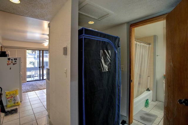 hallway with light tile patterned flooring and a textured ceiling