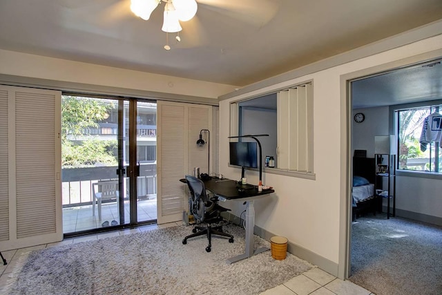 office with a healthy amount of sunlight, light colored carpet, and french doors