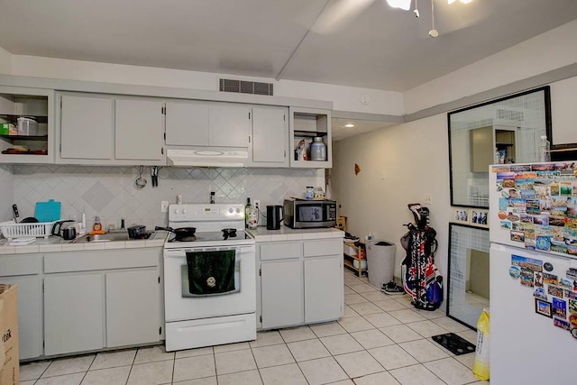 kitchen with backsplash, white appliances, tile countertops, and light tile patterned flooring